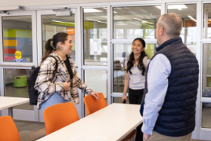 Two students talking with a professor